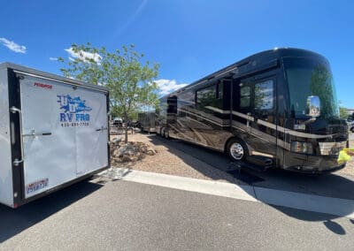 RV angled from the front, next to a trailer